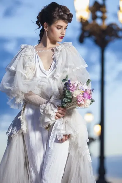 Novia con vestido de tul y encaje, sujetando un ramo de flores de colores, en un reportaje realizado por una fotógrafa de bodas en Madrid.