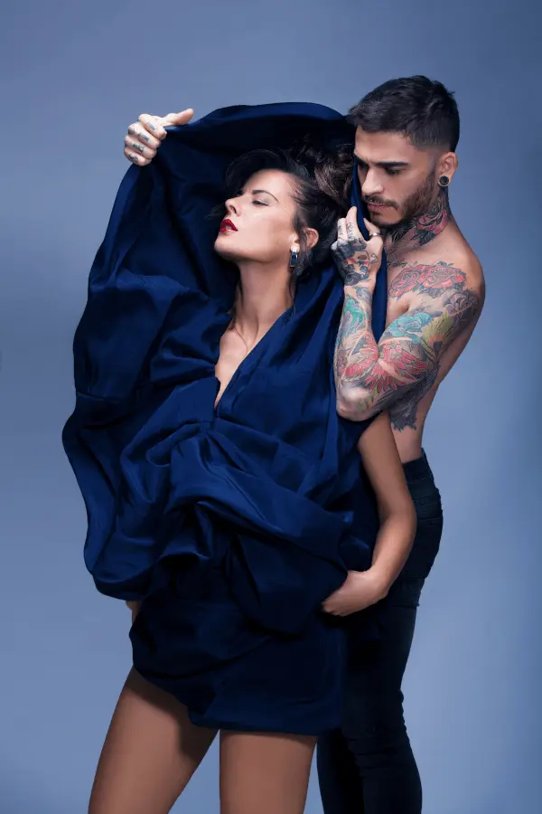 Fotografía Editorial en Madrid para Revistas y Campañas - Sara Iglesias Modelo femenina con tela azul cubriéndola y un hombre tatuado detrás, en una pose artística y conceptual, realizada por fotógrafos en Madrid para editorial.
